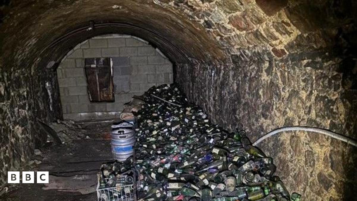 Twnnel gron o dan y ddaear yn seler tafarn Yr Heulyn, gyda miloedd o boteli alcohol a chwrw tryloyw mewn twmpath ar ben ei gilydd. Mae